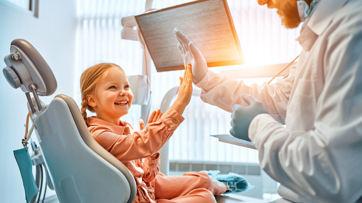 Pediatric dental patient smiling with the dentist